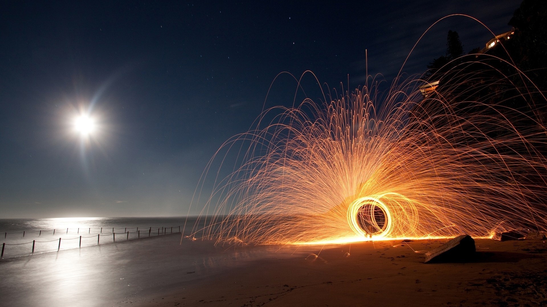 Circular sparkler on a beach at night wallpaper 1920x1080