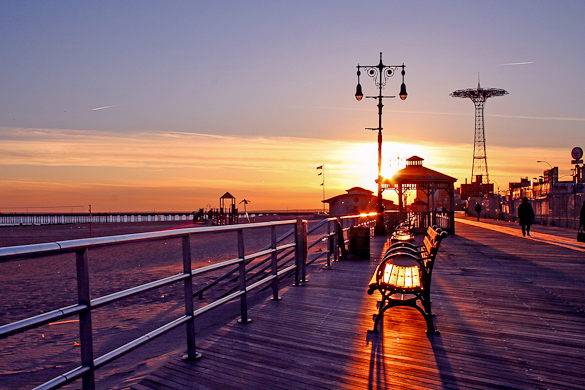 Coney Island boardwalk at Sunset with Parachute Jump in the background 585x390